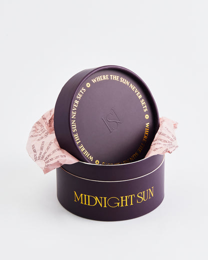 Round purple packaging with 'Midnight Sun' text on a light gray background