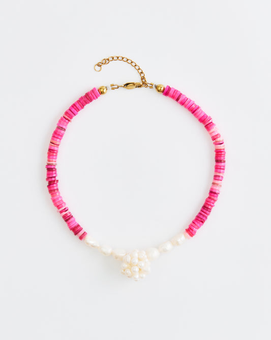 Necklace with pink beads and gold clasp on a white background