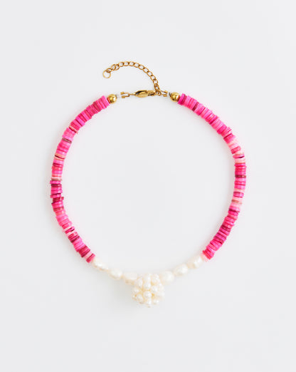 Necklace with pink beads and gold clasp on a white background