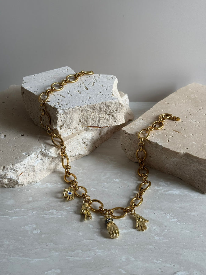 Gold bracelet with charms on a textured surface
