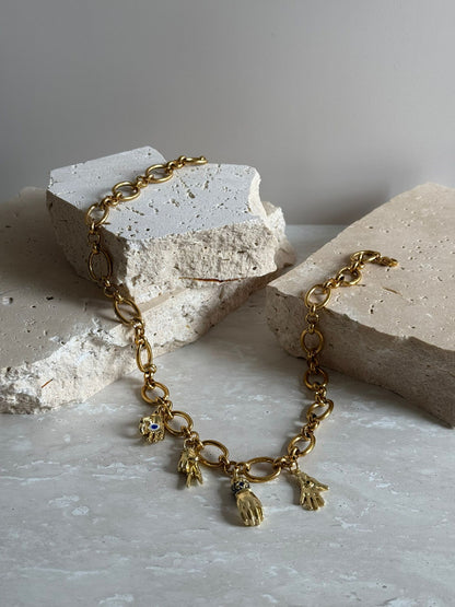 Gold bracelet with charms on a textured surface