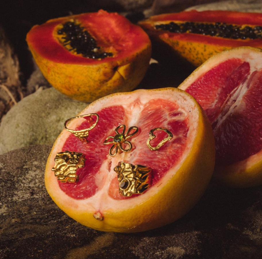 Jewelry set displayed on a halved pomegranate with a natural stone background