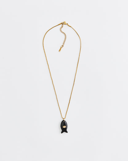 Gold necklace with a black pendant on a white background